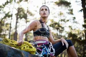 Woman sitting with climbing equipment