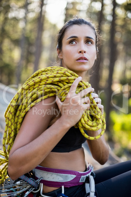 Portrait of woman sitting with climbing equipment