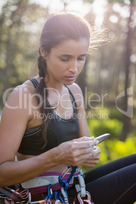 Portrait of woman sitting with climbing equipment