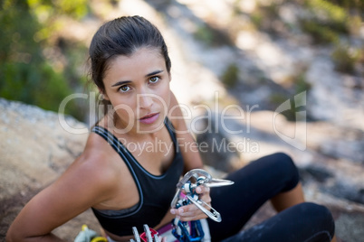 Woman sitting with climbing equipment