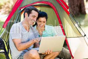 Couple smiling and using a laptop