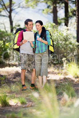 Couple hiking and studying a map