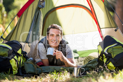 Man laying and holding cup