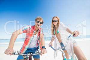 Couple posing with bike on the beach