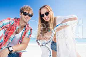 Couple posing with bike on the beach