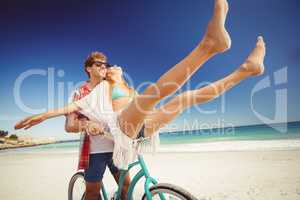 Couple posing with bike on the beach