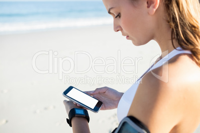 Smiling woman in sportswear texting on smartphone