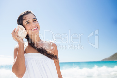 Portrait of smiling woman listening shellfish