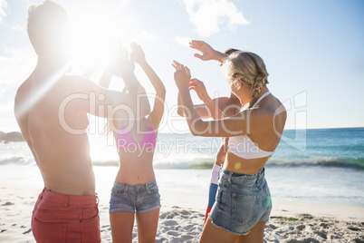 Smiling friends dancing at the beach