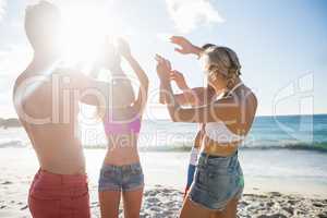 Smiling friends dancing at the beach