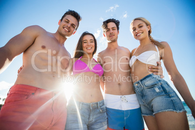 Smiling friends standing at the beach