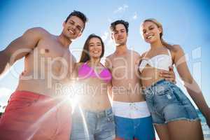 Smiling friends standing at the beach