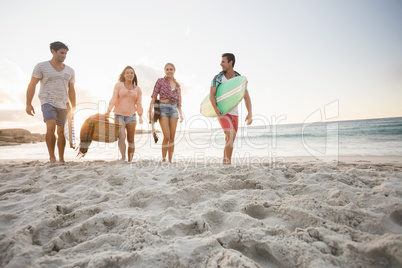 Friends carrying a surfboard and basket