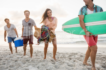 Friends carrying a surfboard and basket