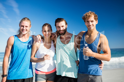 Smiling friends standing at the beach