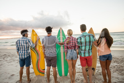 Friends holding a surfboard