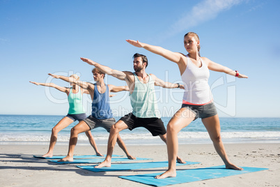 People doing yoga on the beach