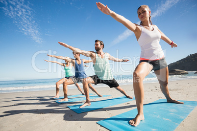 People doing yoga on the beach