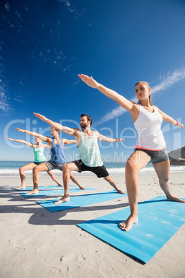 People doing yoga on the beach