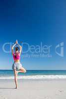 Woman doing yoga on the beach