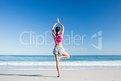 Woman doing yoga on the beach