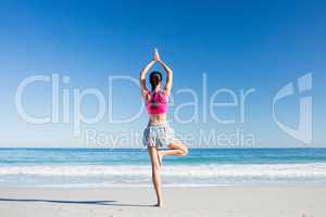 Woman doing yoga on the beach