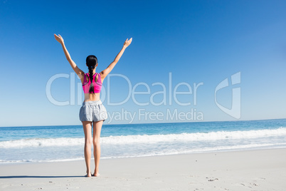 Woman with hands up on the beach