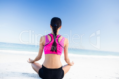 Woman doing yoga on the beach