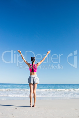 Woman with hands up on the beach