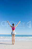 Woman with hands up on the beach