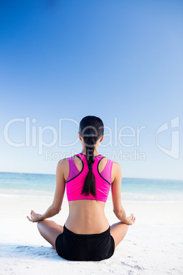 Woman doing yoga on the beach