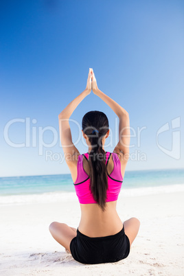 Woman doing yoga on the beach