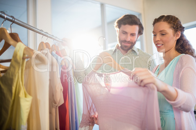 Woman showing shirt to man at shopping mall