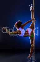 Pole dance. Flexible girl with uv bodyart posing
