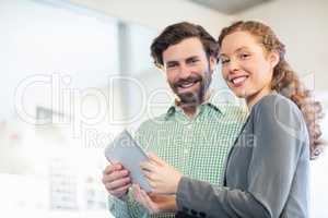 Businessman and businesswoman discuss using digital tablet
