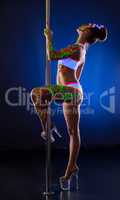 Sexy pole dancer with ultraviolet patterns on body