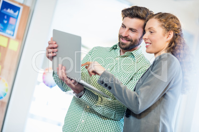 Businessman and businesswoman discuss using computer