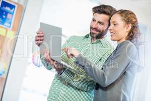 Businessman and businesswoman discuss using computer