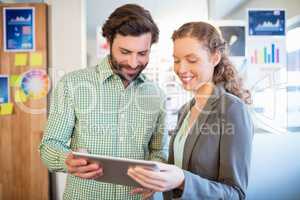 Businessman and businesswoman discuss using tablet