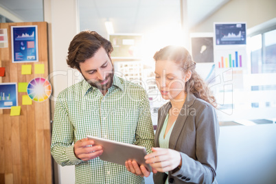 Businessman and businesswoman discuss using tablet