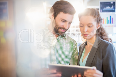 Businessman and businesswoman discuss using tablet