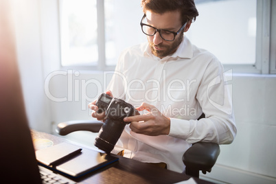 Businessman looking photos on his camera