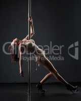 Sensuality and grace. Sexy woman dancing on pole