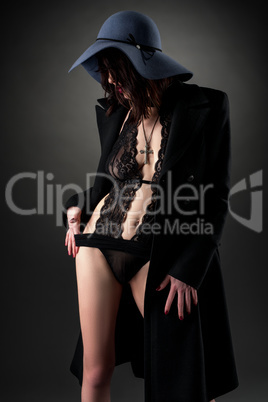 Stylish model wearing lace bodysuit, coat and hat