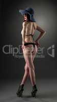 Rear view of slender model in lingerie and hat