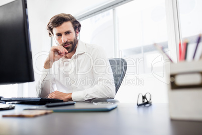 Businessman smiling and posing on his desk