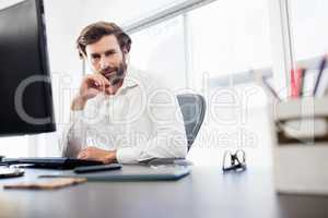 Businessman smiling and posing on his desk