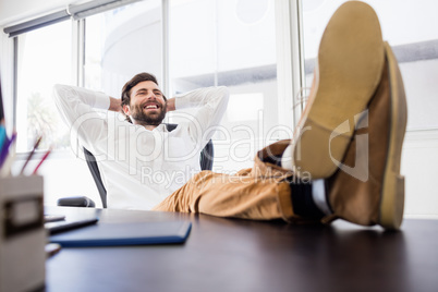 A smiling man relaxing in the office