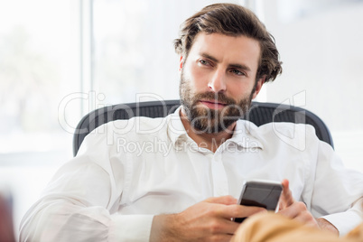 A thinking man holding his phone