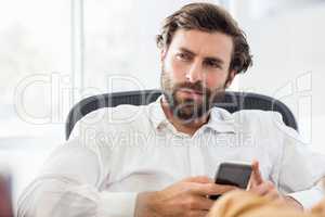 A thinking man holding his phone